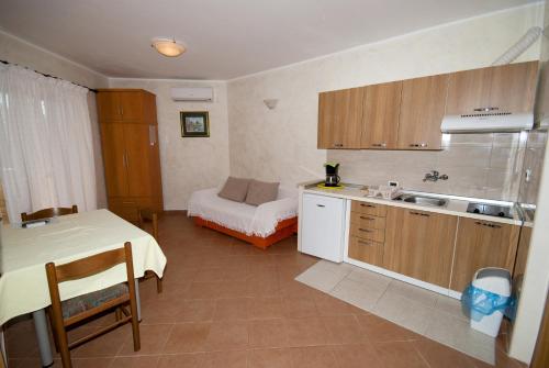 a kitchen with a table and a bed in a room at Guesthouse Villa Lena in Premantura
