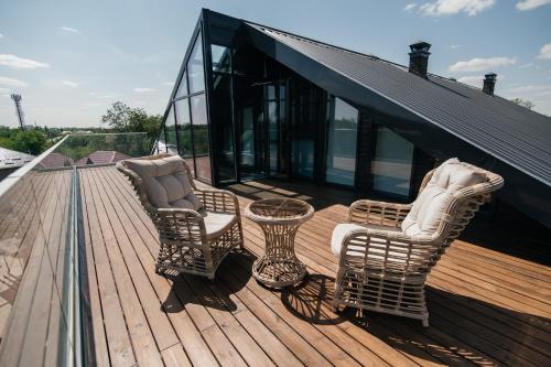 three chairs and a table on a wooden deck at Scandi Hotel in Uralsk