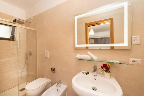 a bathroom with a sink and a toilet and a mirror at Agriturismo I Tesori del Sud Vieste, Puglia in Vieste