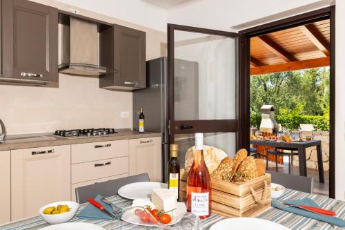 a kitchen with a table with food and wine bottles at Agriturismo I Tesori del Sud Vieste, Puglia in Vieste