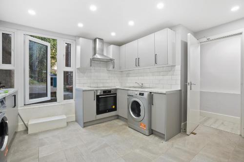 a kitchen with a washer and dryer in it at Luxury Hackney Apartment 10 mins to Liverpool Street in London