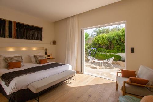 1 dormitorio con 1 cama y puerta corredera de cristal en Hôtel La Caravelle en Calvi