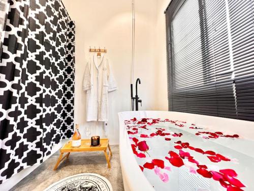 a bathroom with a bath tub with red flowers on it at Studio S Conceptual Homestay Station 18 - Ipoh in Ipoh