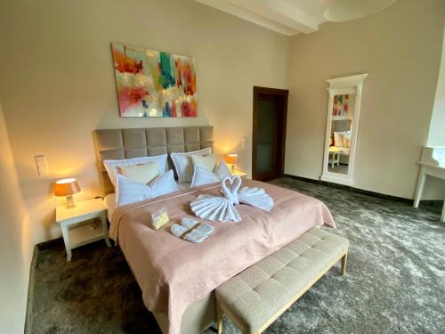 ein Schlafzimmer mit einem großen Bett mit einer Schleife darauf in der Unterkunft Villa Le Palais Quedlinburg in Quedlinburg