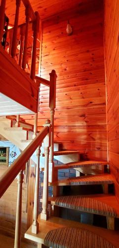 a wooden staircase in a house with wooden walls at Dom Zajezdny in Białowieża