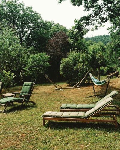 a couple of chairs and a hammock in the grass at La Colombaia Amiata in Arcidosso