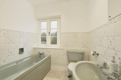 y baño con bañera, aseo y lavamanos. en 2 Lower Spire en Dulverton