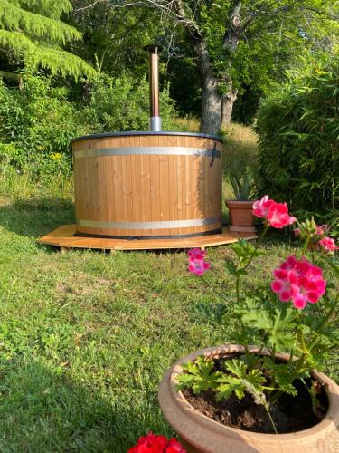 a wooden tub sitting in the grass next to flowers at La Colombaia Amiata in Arcidosso