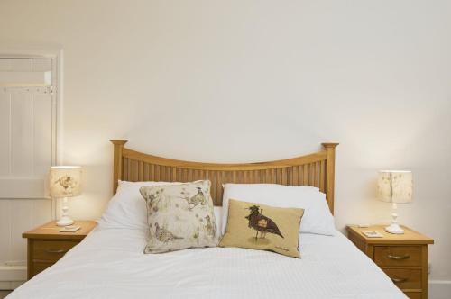 ein Bett mit zwei Lampen und zwei Kissen darauf in der Unterkunft 1 Lower Spire in Dulverton