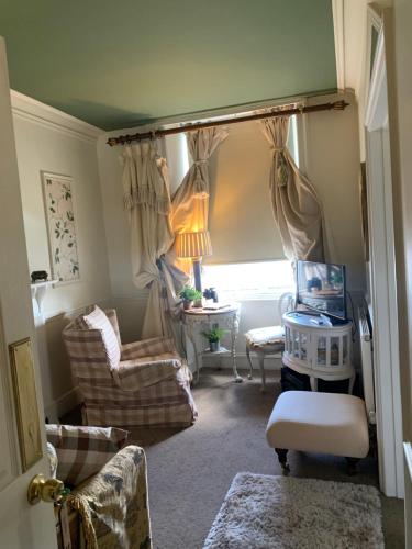a living room with a chair and a table and a window at The Suites At Ty Anne in Beaumaris