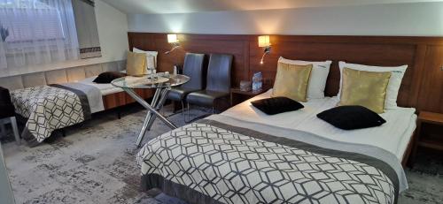 ノヴィ・ソンチにあるCynamonのベッド2台とテーブルが備わるホテルルームです。