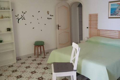 um quarto com uma mesa verde e uma cadeira em Relais Zio Vincenzo Casa Positano em Positano