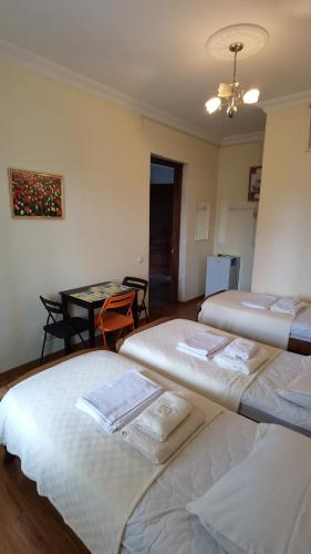 a room with three beds and a table in it at Guest House Madonna in K'obulet'i