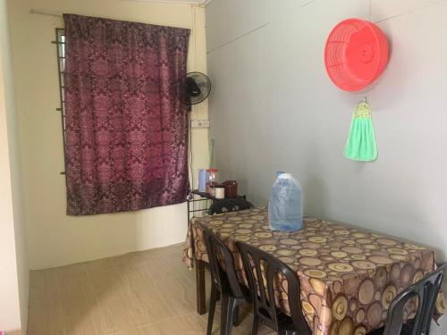 a room with a table with chairs and a window at Tina Homestay Budget in Ketereh
