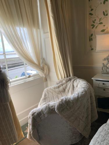 a bedroom with a bed with a blanket and a window at The Suites At Ty Anne in Beaumaris