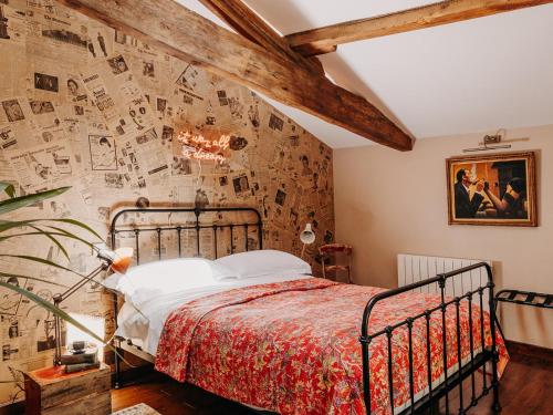 1 dormitorio con 1 cama y una pared cubierta de fotografías en Manoir Laurette, en Saint-Martin-Petit