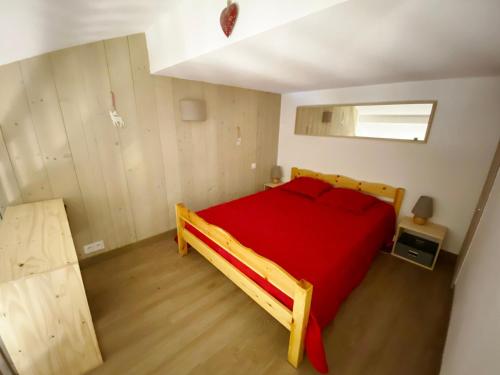 sypialnia z drewnianym łóżkiem z czerwoną pościelą w obiekcie Charmant 2 Pièces Rénové 6 Pers, Balcon, Proche Pistes et Commerces - Morillon 1100 - FR-1-412-82 w mieście Morillon