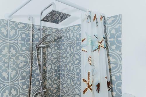 een badkamer met een douche met blauwe en witte tegels bij Lemon Tree Rooms in Ischia