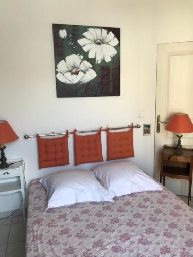 1 dormitorio con 1 cama con 2 lámparas y una foto en la pared en Chambre Abri Urbain en Montpellier