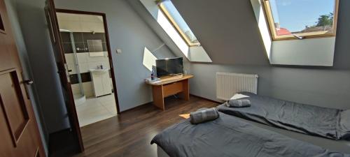een slaapkamer met een bed, een bureau en ramen bij Mrowisko 