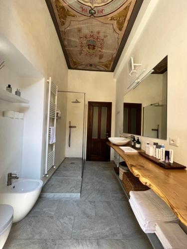 Appartamento La Corte في أوليدجو: حمام به مغسلتين وحوض استحمام ومرآة