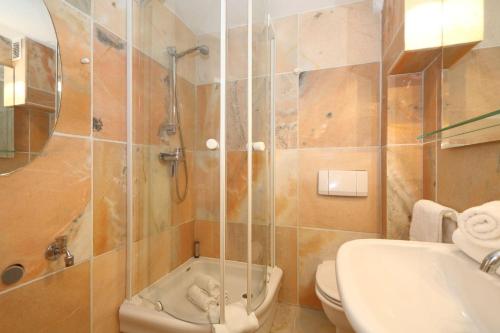 a bathroom with a shower and a toilet and a sink at Haus-Wattblick-Appartement-M-W-U in Braderup