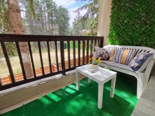 a porch with a couch and a table on a balcony at Gold Infinity in Velingrad