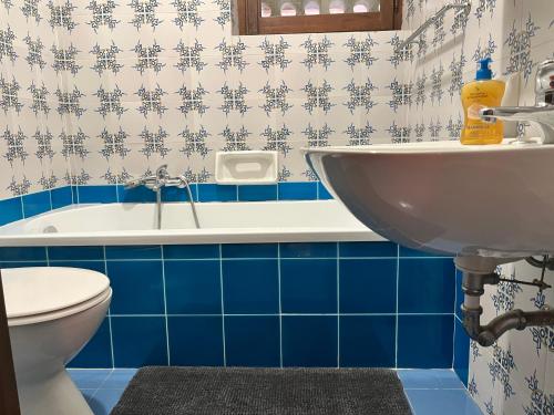 a bathroom with a sink and a tub with blue tiles at Villa Margherita in Alghero