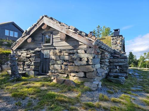 una vieja casa de piedra en un campo en Hytte i Hallingdal/Flå, en Flå