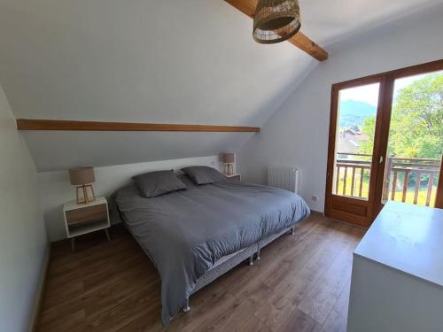 une chambre avec un lit et une grande fenêtre dans l'établissement Appartement Douceur entre lac et montagnes, à Saint-Jorioz