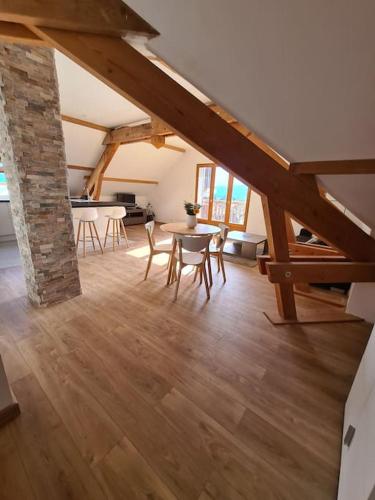 un salon avec une table et des chaises dans un immeuble dans l'établissement Appartement Douceur entre lac et montagnes, à Saint-Jorioz