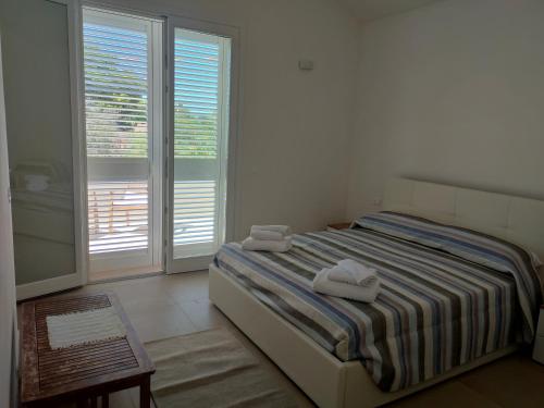 a bedroom with a bed with two towels on it at La casetta della Pigna Verde in Marsala