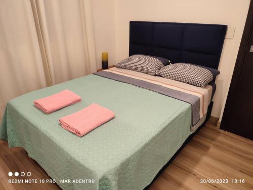 ein Bett mit zwei rosa Handtüchern darüber in der Unterkunft Mar Adentro Lujoso Departamento con Playa in Santa Cruz de la Sierra