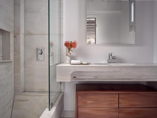 a bathroom with a sink and a shower at Belvedere Mykonos - Main Hotel - The Leading Hotels of the World in Mýkonos City