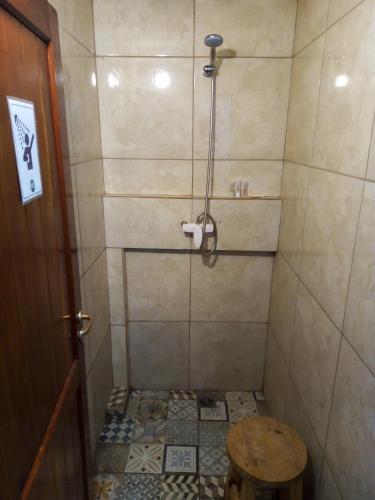 a bathroom with a shower with a stool in it at Hostel Piltri in El Bolsón