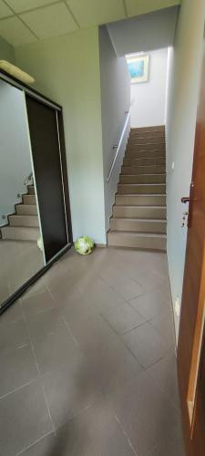 an empty room with stairs and a door and a hallway at Mrowisko in Masłowice
