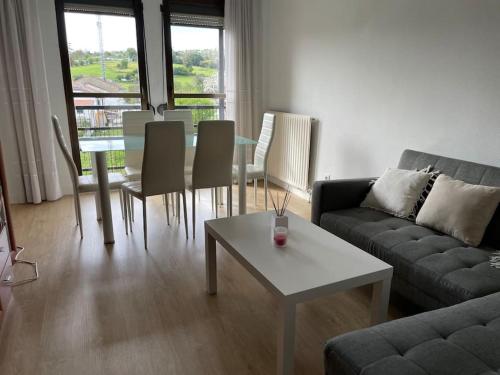 ein Wohnzimmer mit einem Sofa und einem Tisch mit Stühlen in der Unterkunft Precioso duplex en Oviedo WIFI in Oviedo