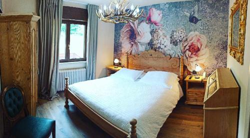 1 dormitorio con 1 cama y una pintura en la pared en La Bocchetta Romantic Spa Hotel e Ristorante en Conco