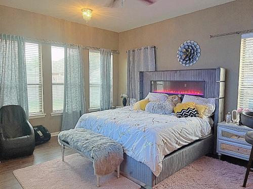 a bedroom with a bed and a chair and windows at The Queens luxury palace in Grand Prairie