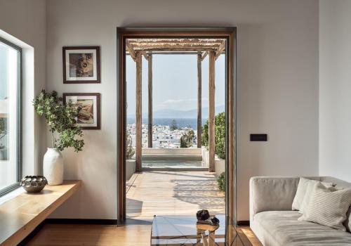 a living room with a door leading to a patio at Belvedere Mykonos - Main Hotel - The Leading Hotels of the World in Mýkonos City
