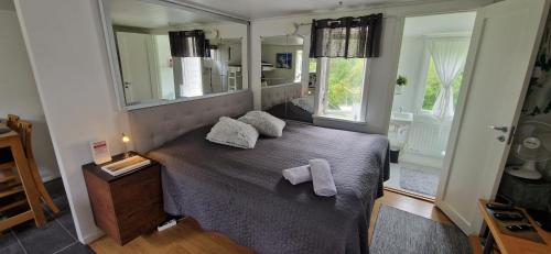 a bedroom with a bed with a large mirror at Humlebo in Åsa