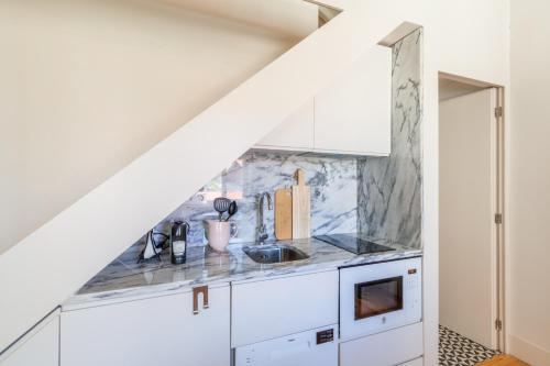 a kitchen with white cabinets and a sink at D&S - JB Apartments in Porto