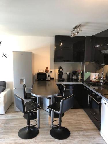 une cuisine avec une table et des chaises dans une pièce dans l'établissement Bord canal tranquillité demain nous appartient, à Sète