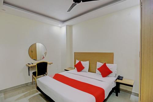 - une chambre avec un lit, un bureau et un miroir dans l'établissement Hotel Dafodil, à Allahābād