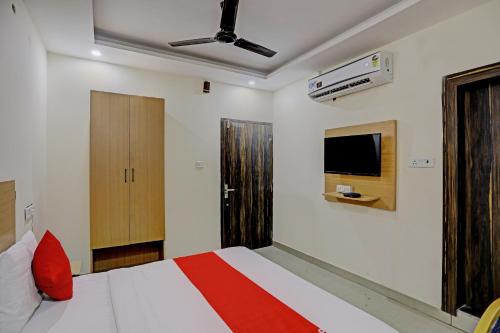 - une chambre avec un lit et une télévision murale dans l'établissement Hotel Dafodil, à Allahābād