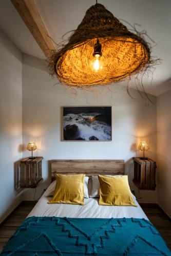 une chambre avec un lit et un lustre dans l'établissement Magic Surf House, à Lacanau