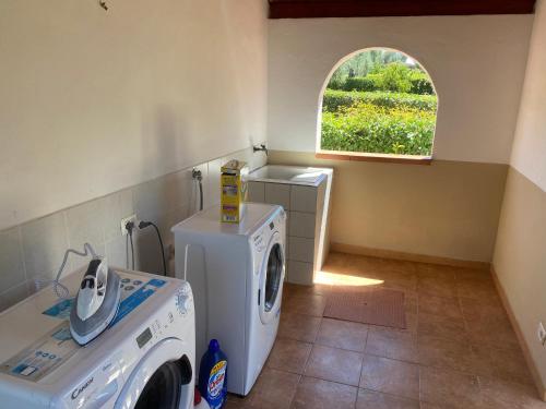 a laundry room with a washer and a window at Agriturismo I Tesori del Sud Vieste, Puglia in Vieste