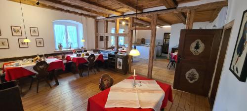 ein Restaurant mit roten Tischen und Stühlen in einem Zimmer in der Unterkunft Pension Kaiserhaus in Ühlingen-Birkendorf