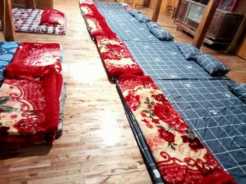 eine Reihe roter Betten auf einem Holzboden in der Unterkunft Thủy Cường in Hòa Bình