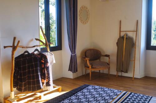 a room with a table and a chair and a window at Les Tanalis - Chambres d'hôtes & Gîte in Gurs